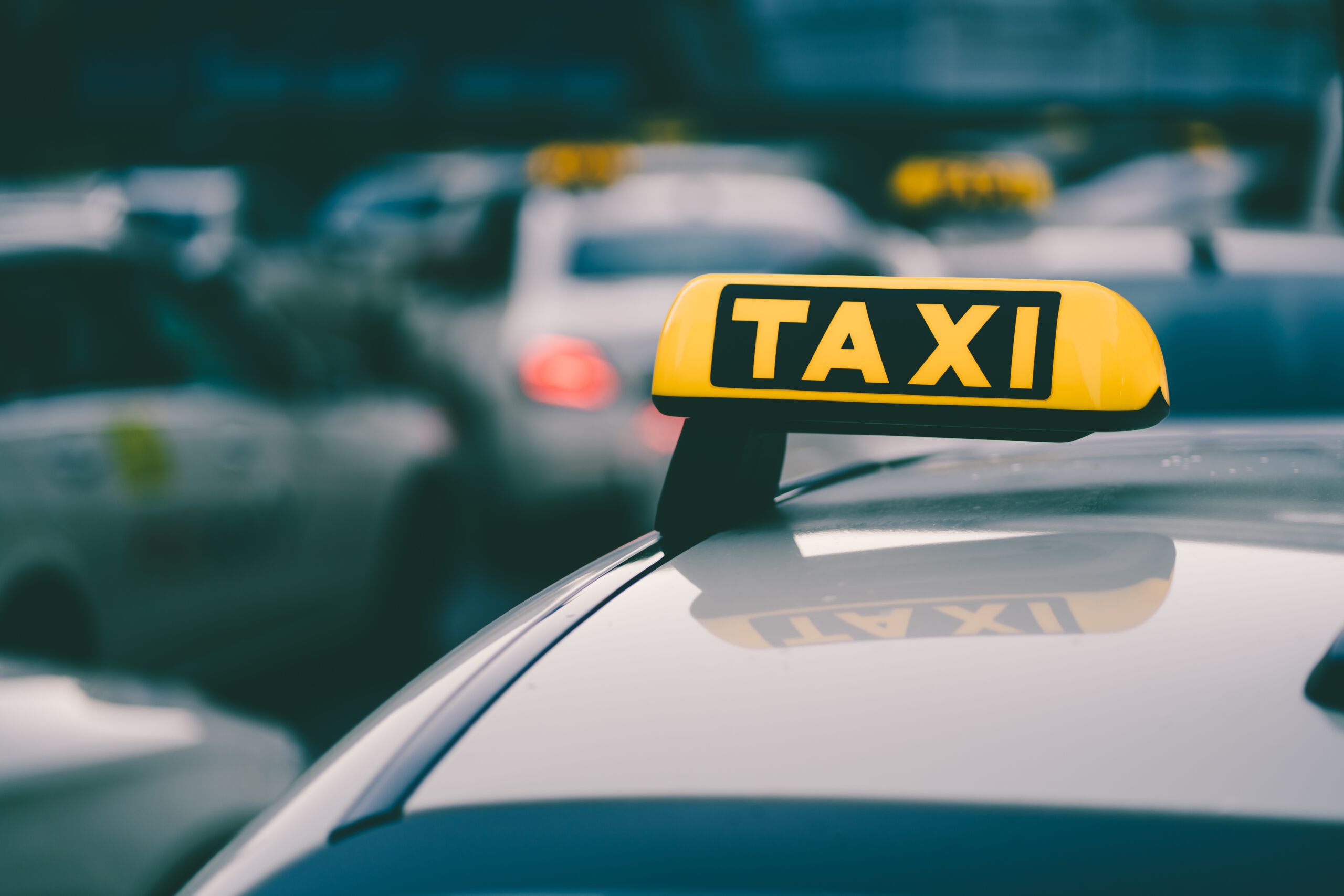 selektive fokusaufnahme eines gelben taxischildes im stau scaled
